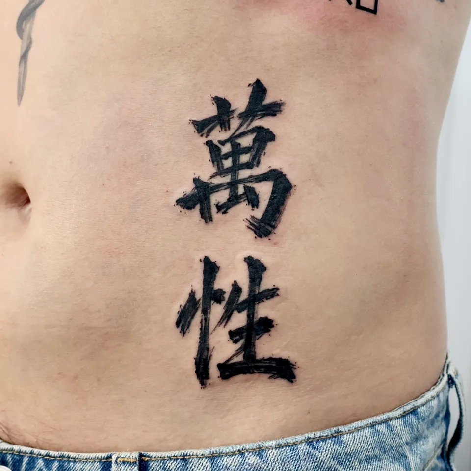 복부의 붓글씨체 한자 두 글자를 가까이서 본 사진, 거친 붓 획과 가장자리의 작은 번짐 점이 보임