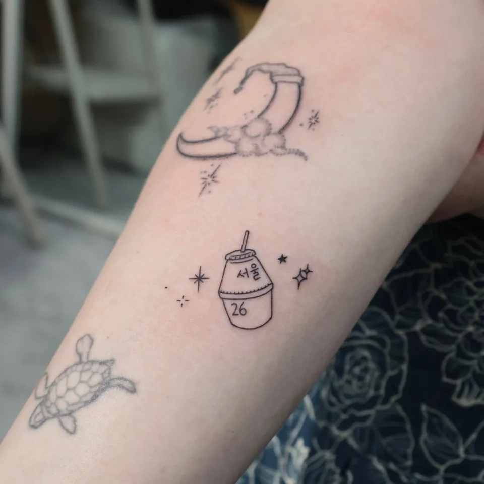 Tattoo artwork shared by Yeonjae Tattoo — A tiny Seoul souvenir tattoo. 🥤✨ (2/2)
