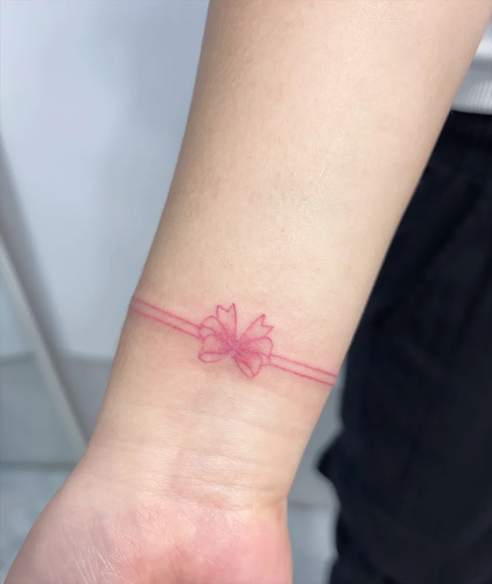 Tattoo artwork shared by Yeonjae Tattoo — A delicate pink line tattoo wrapping naturally…